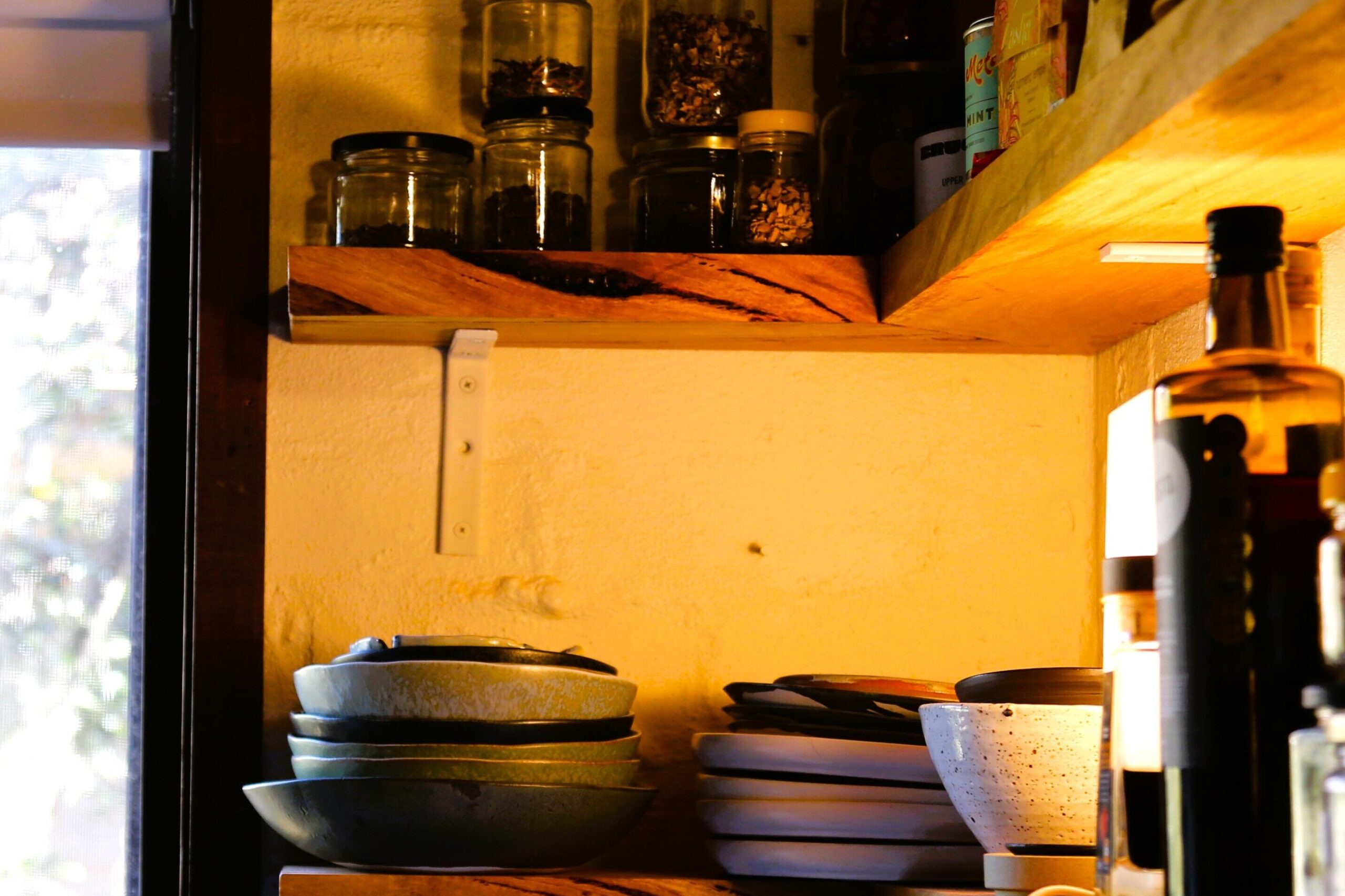 shelves in the Sydney properties' kitchen with bowls, plates and various jars of spices